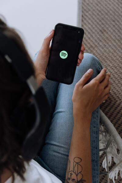 Woman using phone to listen to her favorite music on Spotify.