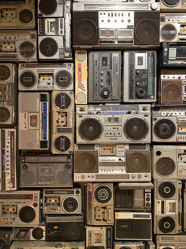 Wall of retro speakers and boomboxes, providing a nostalgic vibe.