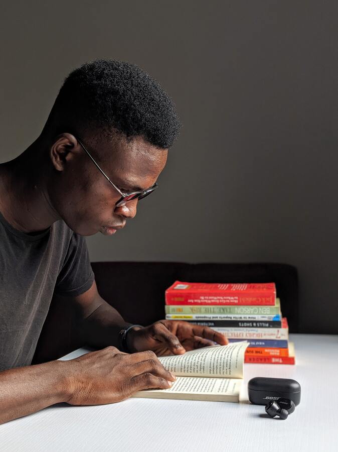 Focused man deep in study, learning through books.